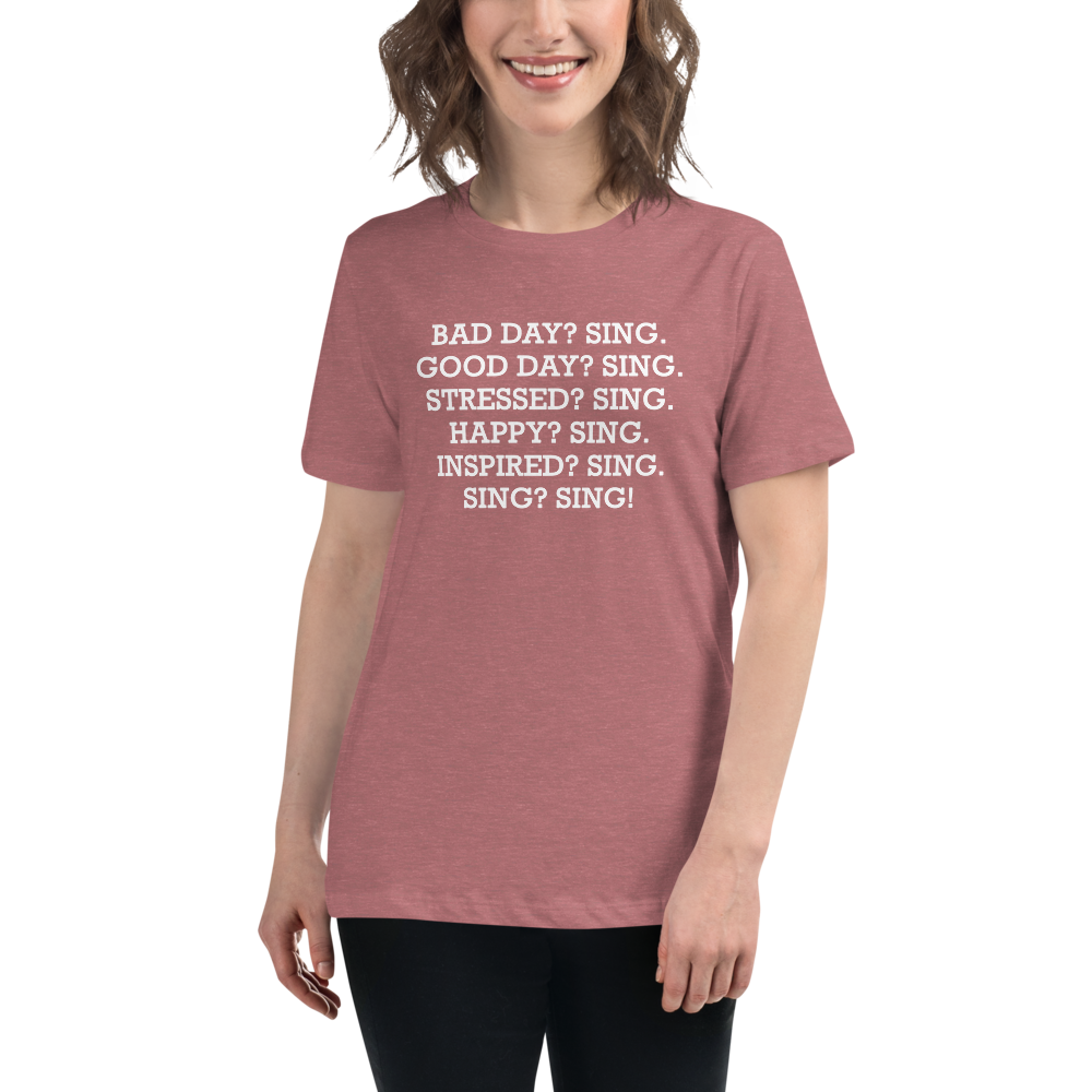 "Bad Day? Sing. Good Day? Sing. Stressed? Sing. Happy? Sing. Inspired? Sing. Sing? Sing!" printed on a heather mauve women's relaxed t-shirt worn by a female