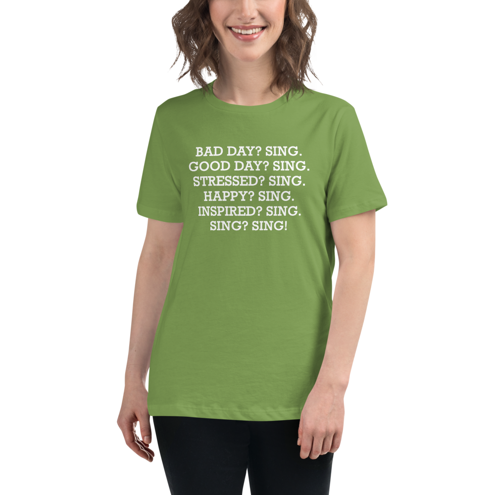 "Bad Day? Sing. Good Day? Sing. Stressed? Sing. Happy? Sing. Inspired? Sing. Sing? Sing!" printed on a leaf women's relaxed t-shirt worn by a female