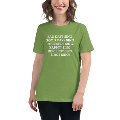"Bad Day? Sing. Good Day? Sing. Stressed? Sing. Happy? Sing. Inspired? Sing. Sing? Sing!" printed on a leaf women's relaxed t-shirt worn by a female