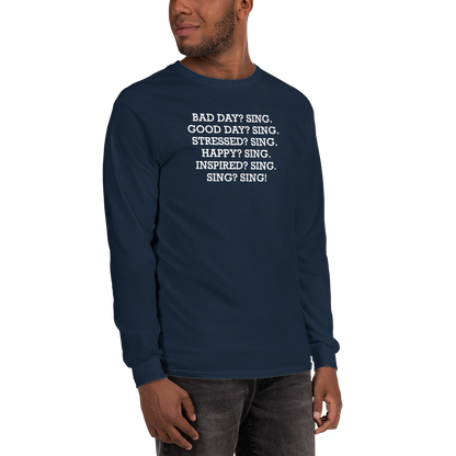 "Bad Day? Sing. Good Day? Sing. Stressed? Sing. Happy? Sing. Inspired? Sing. Sing? Sing!" printed on a navy men's long sleeve shirt worn by a male