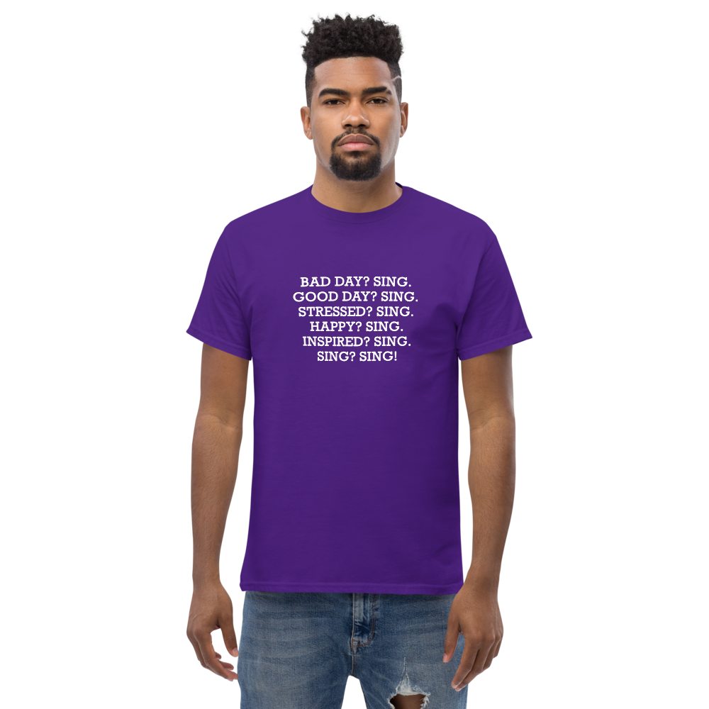 "Bad Day? Sing. Good Day? Sing. Stressed? Sing. Happy? Sing. Inspired? Sing. Sing? Sing!" printed on a purple unisex classic tee worn by a male