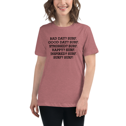 "Bad Day? Surf. Good Day? Surf. Stressed? Surf. Happy? Surf. Inspired? Surf. Surf? Surf!" printed on a heather mauve women's relaxed t-shirt worn by a female