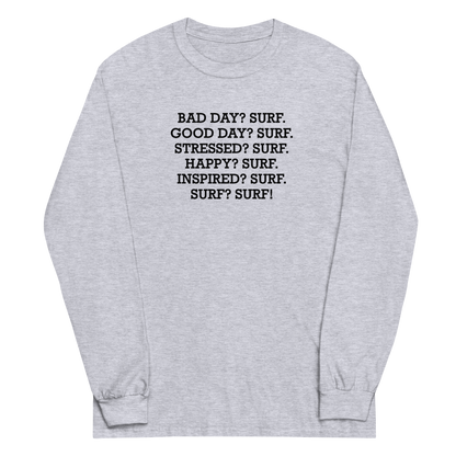 "Bad Day? Surf. Good Day? Surf. Stressed? Surf. Happy? Surf. Inspired? Surf. Surf? Surf!" printed on a sport grey men's long sleeve shirt laying on a flat surface