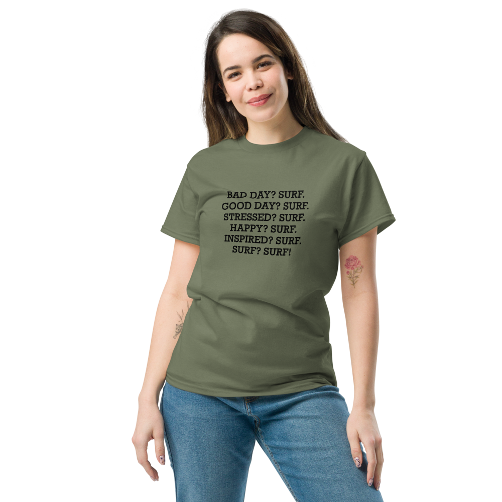 "Bad Day? Surf. Good Day? Surf. Stressed? Surf. Happy? Surf. Inspired? Surf. Surf? Surf!" printed on a military green unisex classic tee worn by a female