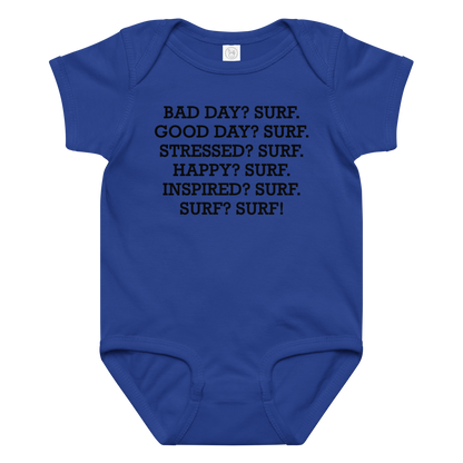 "Bad Day? Surf. Good Day? Surf. Stressed? Surf. Happy? Surf. Inspired? Surf. Surf? Surf!" printed on a royal baby jersey bodysuit laying on a flat surface amongst other clothes