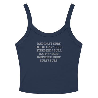 "Bad Day? Surf. Good Day? Surf. Stressed? Surf. Happy? Surf. Inspired? Surf. Surf? Surf!" printed on a solid navy blend women's micro-rib tanktop laying on a flat surface amongst sunglasses and shorts