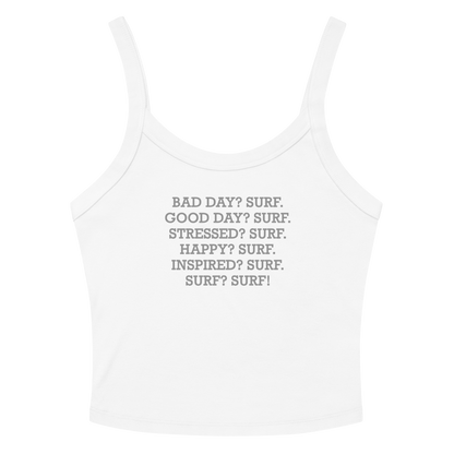"Bad Day? Surf. Good Day? Surf. Stressed? Surf. Happy? Surf. Inspired? Surf. Surf? Surf!" printed on a solid white blend women's micro-rib tanktop laying on a flat surface amongst sunglasses and shorts