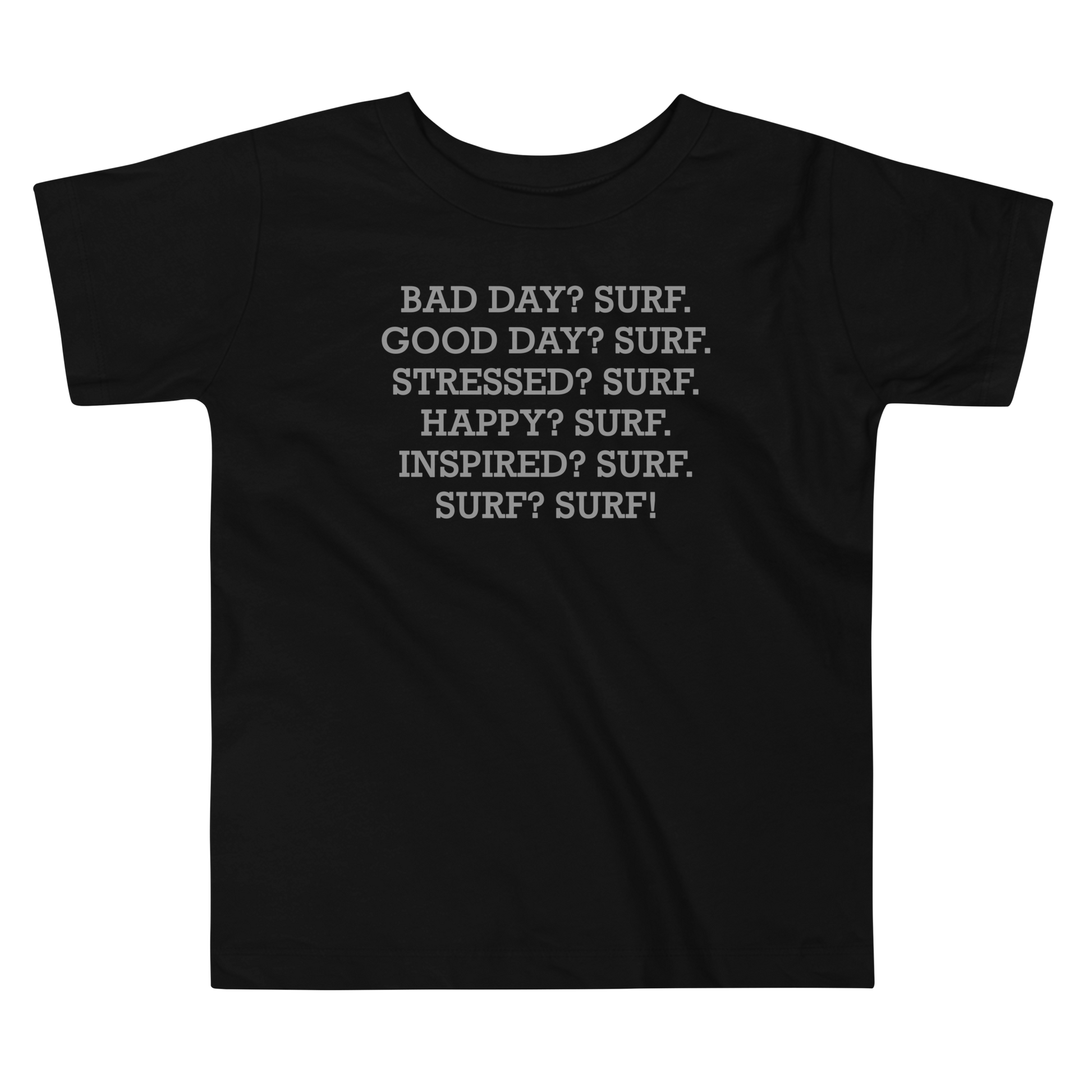 "Bad Day? Surf. Good Day? Surf. Stressed? Surf. Happy? Surf. Inspired? Surf. Surf? Surf!" printed on a black toddler short sleeve tee laying on a flat surface