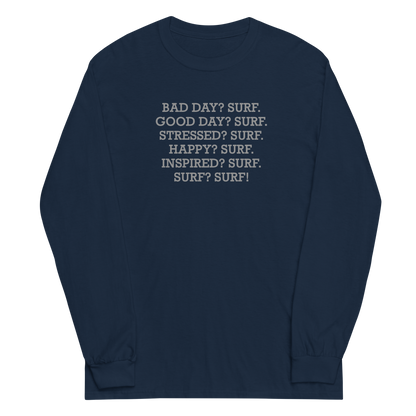 "Bad Day? Surf. Good Day? Surf. Stressed? Surf. Happy? Surf. Inspired? Surf. Surf? Surf!" printed on a navy men's long sleeve shirt laying on a flat surface