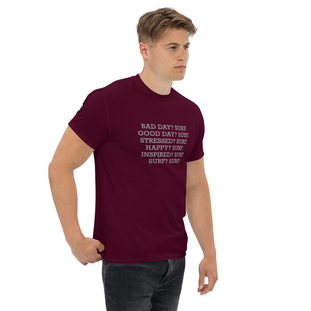 "Bad Day? Surf. Good Day? Surf. Stressed? Surf. Happy? Surf. Inspired? Surf. Surf? Surf!" printed on a maroon unisex classic tee worn by a male