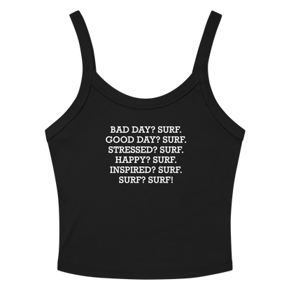 "Bad Day? Surf. Good Day? Surf. Stressed? Surf. Happy? Surf. Inspired? Surf. Surf? Surf!" printed on a solid black blend women's micro-rib tanktop laying on a flat surface amongst sunglasses and shorts