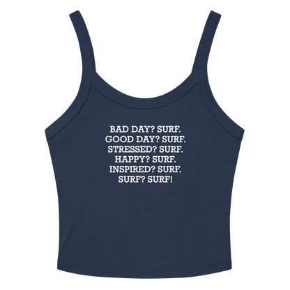 "Bad Day? Surf. Good Day? Surf. Stressed? Surf. Happy? Surf. Inspired? Surf. Surf? Surf!" printed on a solid navy blend women's micro-rib tanktop laying on a flat surface amongst sunglasses and shorts
