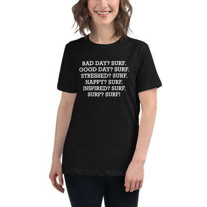 "Bad Day? Surf. Good Day? Surf. Stressed? Surf. Happy? Surf. Inspired? Surf. Surf? Surf!" printed on a black women's relaxed t-shirt worn by a female