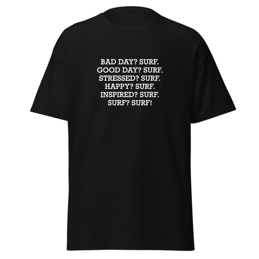 "Bad Day? Surf. Good Day? Surf. Stressed? Surf. Happy? Surf. Inspired? Surf. Surf? Surf!" printed on a black unisex classic tee laying on a flat surface