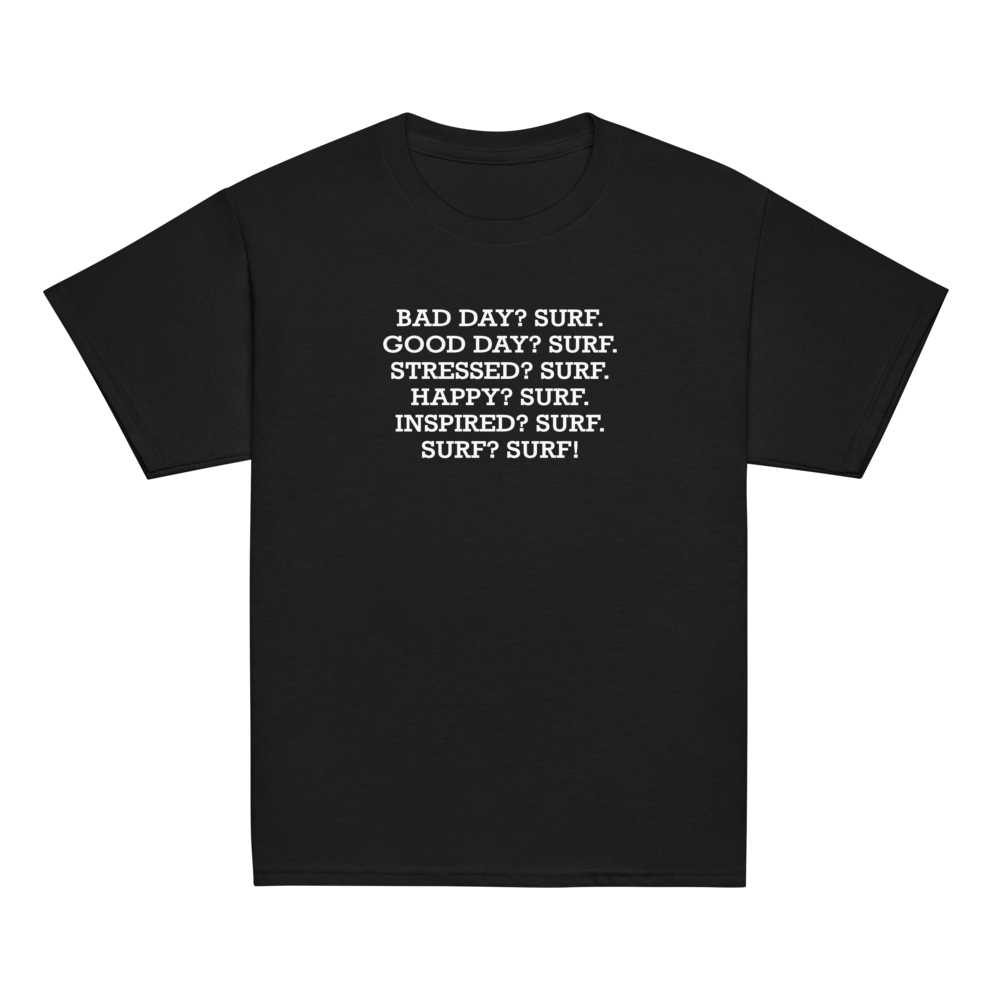 "Bad Day? Surf. Good Day? Surf. Stressed? Surf. Happy? Surf. Inspired? Surf. Surf? Surf!" printed on a black youth classic tee laying on a flat surface