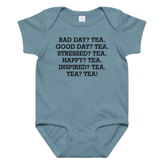"Bad Day? Tea. Good Day? Tea. Stressed? Tea. Happy? Tea. Inspired? Tea. Tea? Tea!" printed on a vintage indigo baby jersey bodysuit laying on a flat surface amongst other clothes