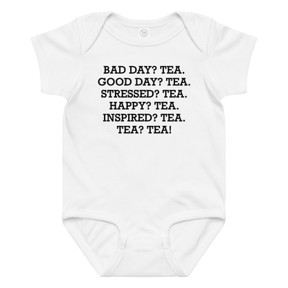 "Bad Day? Tea. Good Day? Tea. Stressed? Tea. Happy? Tea. Inspired? Tea. Tea? Tea!" printed on a white baby jersey bodysuit laying on a flat surface amongst other clothes
