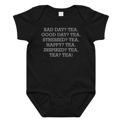 "Bad Day? Tea. Good Day? Tea. Stressed? Tea. Happy? Tea. Inspired? Tea. Tea? Tea!" printed on a black baby jersey bodysuit laying on a flat surface amongst other clothes