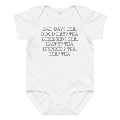 "Bad Day? Tea. Good Day? Tea. Stressed? Tea. Happy? Tea. Inspired? Tea. Tea? Tea!" printed on a white baby jersey bodysuit laying on a flat surface amongst other clothes