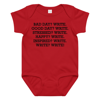 "Bad Day? Write. Good Day? Write. Stressed? Write. Happy? Write. Inspired? Write. Write? Write!" printed on a red baby jersey bodysuit laying on a flat surface amongst other clothes