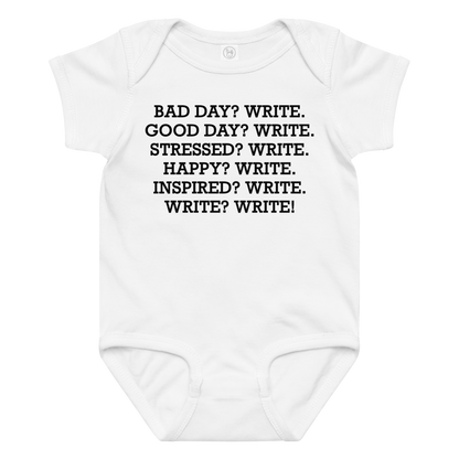 "Bad Day? Write. Good Day? Write. Stressed? Write. Happy? Write. Inspired? Write. Write? Write!" printed on a white baby jersey bodysuit laying on a flat surface amongst other clothes