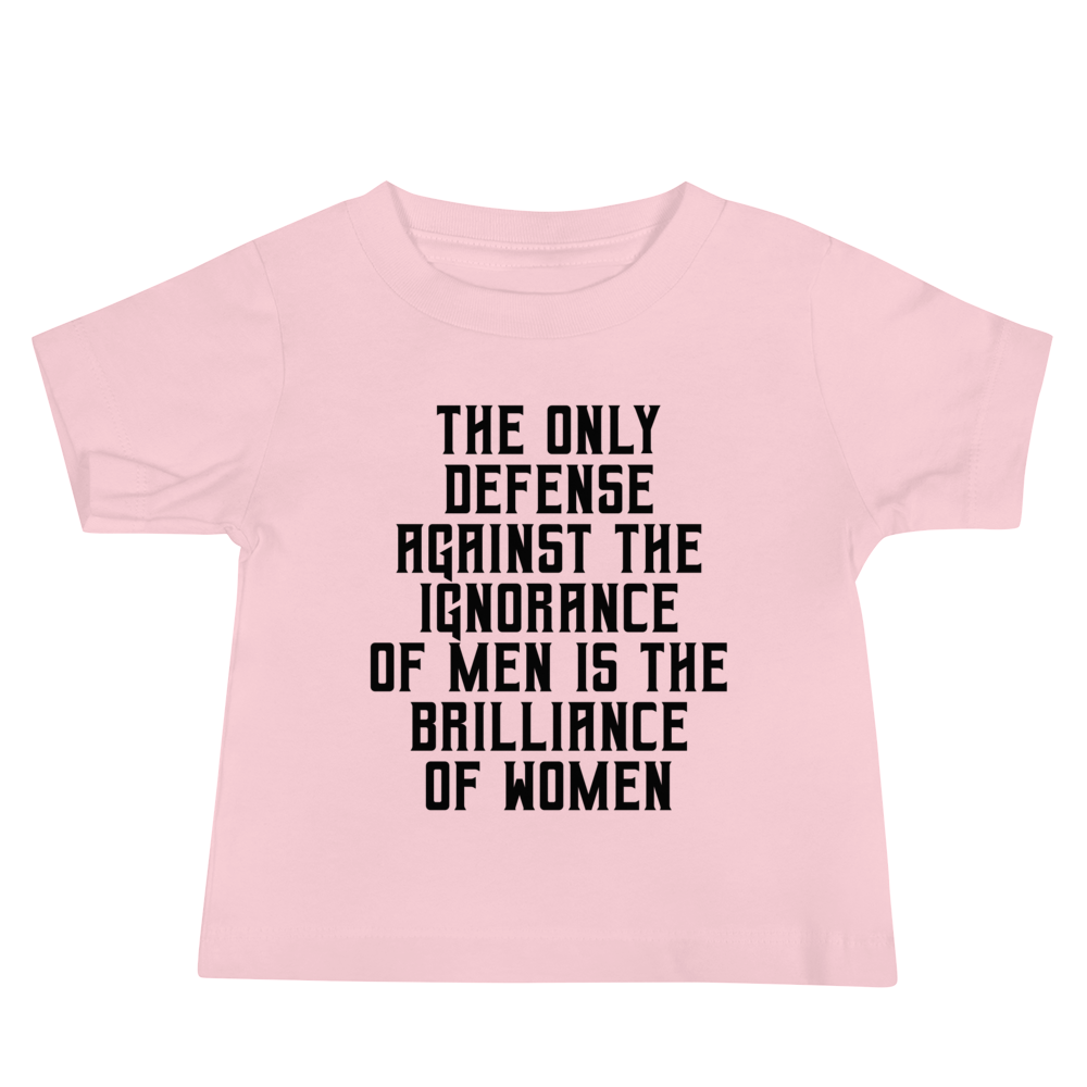 "The Only defense against the ignorance of men is the brilliance of women" printed on a pink baby jersey short sleeve tee laying on a flat surface