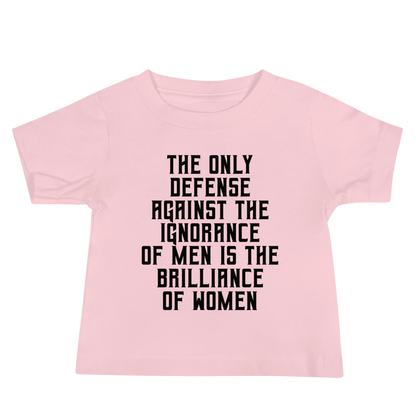 "The Only defense against the ignorance of men is the brilliance of women" printed on a pink baby jersey short sleeve tee laying on a flat surface