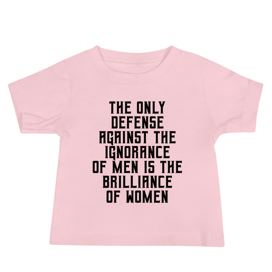 "The Only defense against the ignorance of men is the brilliance of women" printed on a pink baby jersey short sleeve tee laying on a flat surface