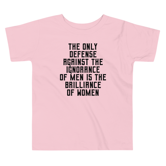 "The Only defense against the ignorance of men is the brilliance of women" printed on a pink toddler short sleeve tee laying on a flat surface