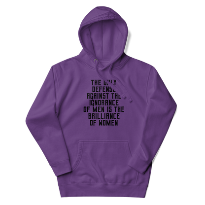 "The Only defense against the ignorance of men is the brilliance of women" printed on a purple unisex hoodie laying on a flat surface with the hood up