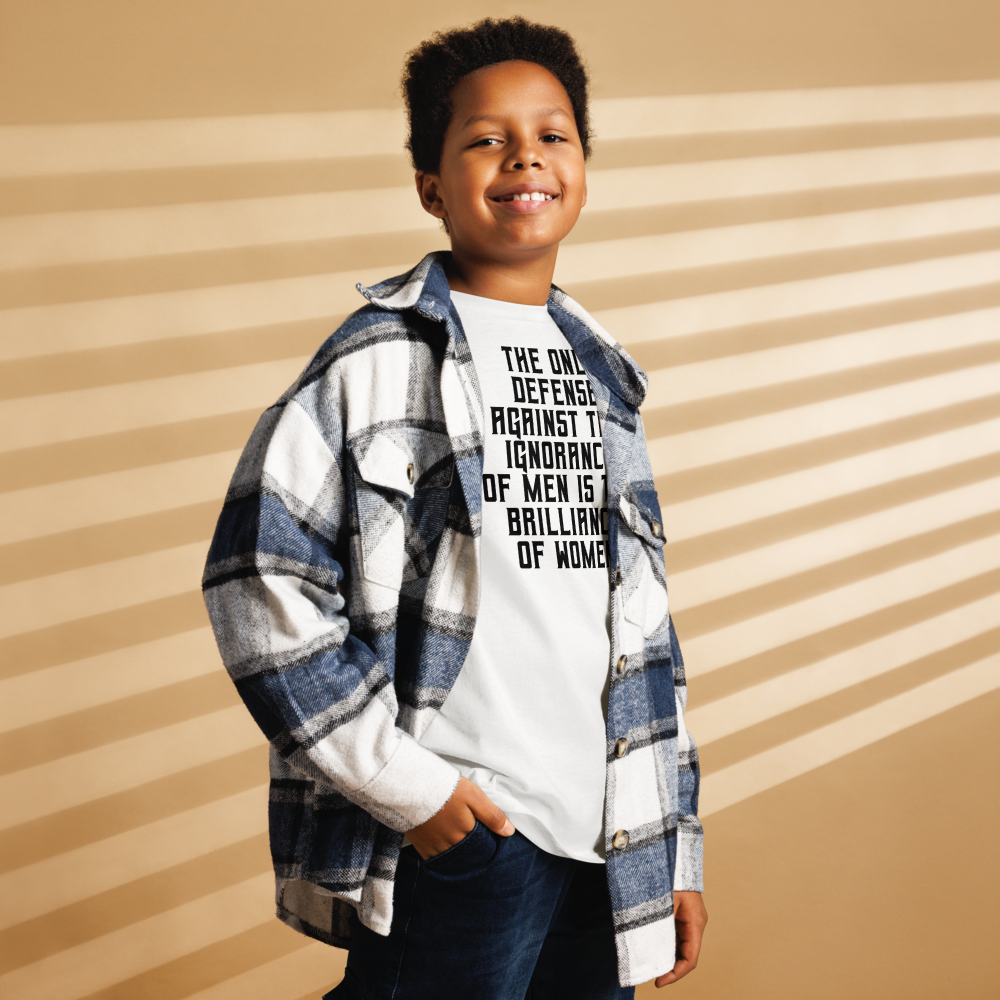 "The Only defense against the ignorance of men is the brilliance of women" printed on a white youth classic tee worn by a male also wearing a jacket