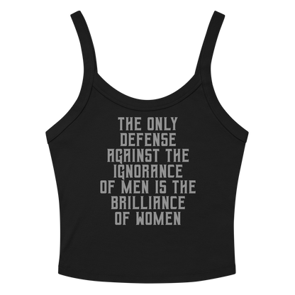 "The Only defense against the ignorance of men is the brilliance of women" printed on a solid black blend women's micro-rib tanktop laying on a flat surface amongst sunglasses and shorts