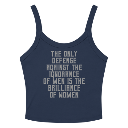 "The Only defense against the ignorance of men is the brilliance of women" printed on a solid navy blend women's micro-rib tanktop laying on a flat surface amongst sunglasses and shorts