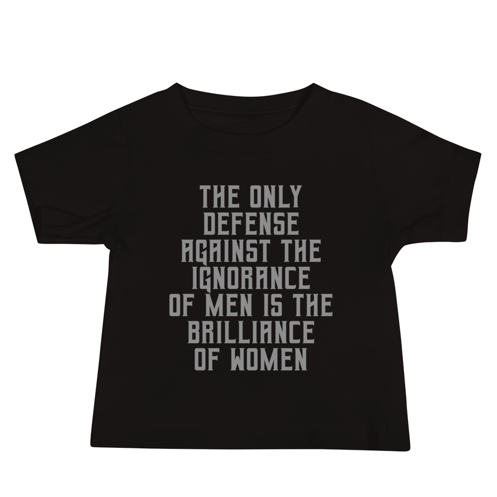 "The Only defense against the ignorance of men is the brilliance of women" printed on a black baby jersey short sleeve tee laying on a flat surface