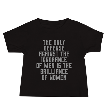"The Only defense against the ignorance of men is the brilliance of women" printed on a black baby jersey short sleeve tee laying on a flat surface