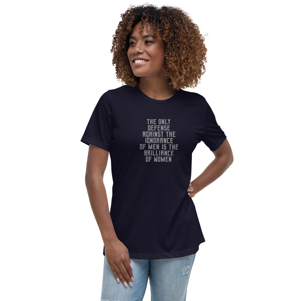 "The Only defense against the ignorance of men is the brilliance of women" printed on a navy women's relaxed t-shirt worn by a female
