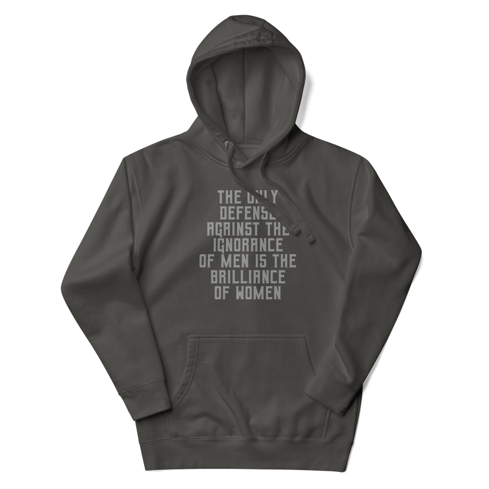 "The Only defense against the ignorance of men is the brilliance of women" printed on a vintage black unisex hoodie laying on a flat surface with the hood up
