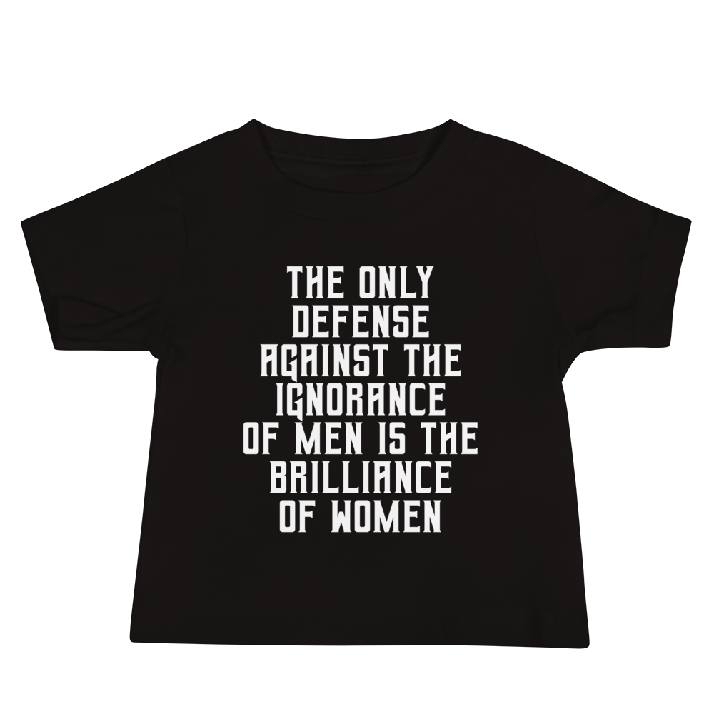 "The Only defense against the ignorance of men is the brilliance of women" printed on a black baby jersey short sleeve tee laying on a flat surface