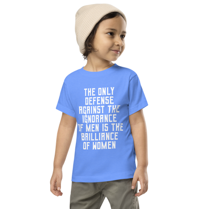 "The Only defense against the ignorance of men is the brilliance of women" printed on a heather columbia blue toddler short sleeve tee worn by a male wearing a cap