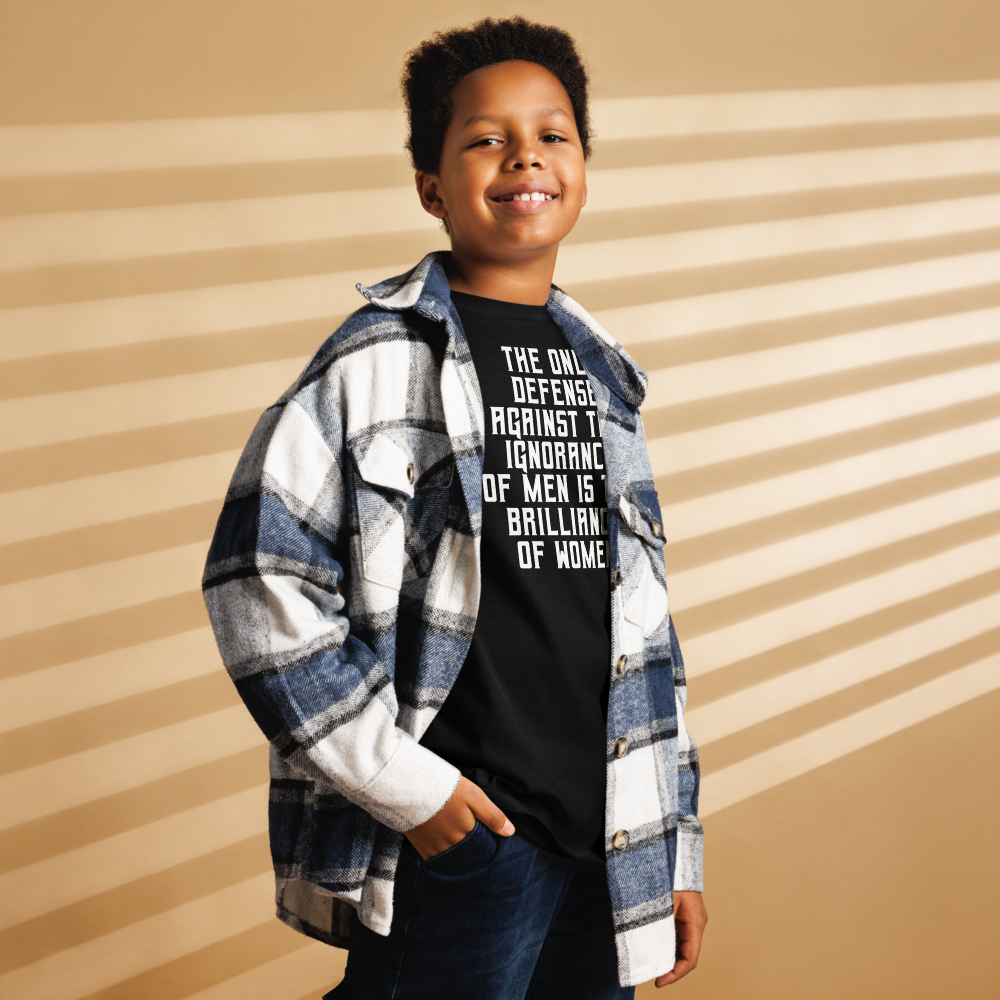 "The Only defense against the ignorance of men is the brilliance of women" printed on a black youth classic tee worn by a male also wearing a jacket