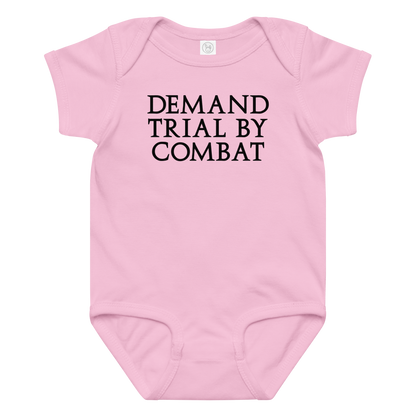 "Demand trial by combat" printed on a pink baby jersey bodysuit laying on a flat surface amongst other clothes