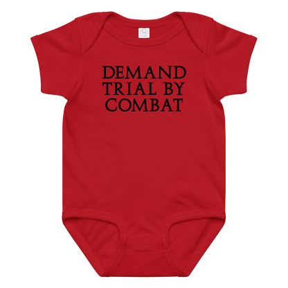 "Demand trial by combat" printed on a red baby jersey bodysuit laying on a flat surface amongst other clothes