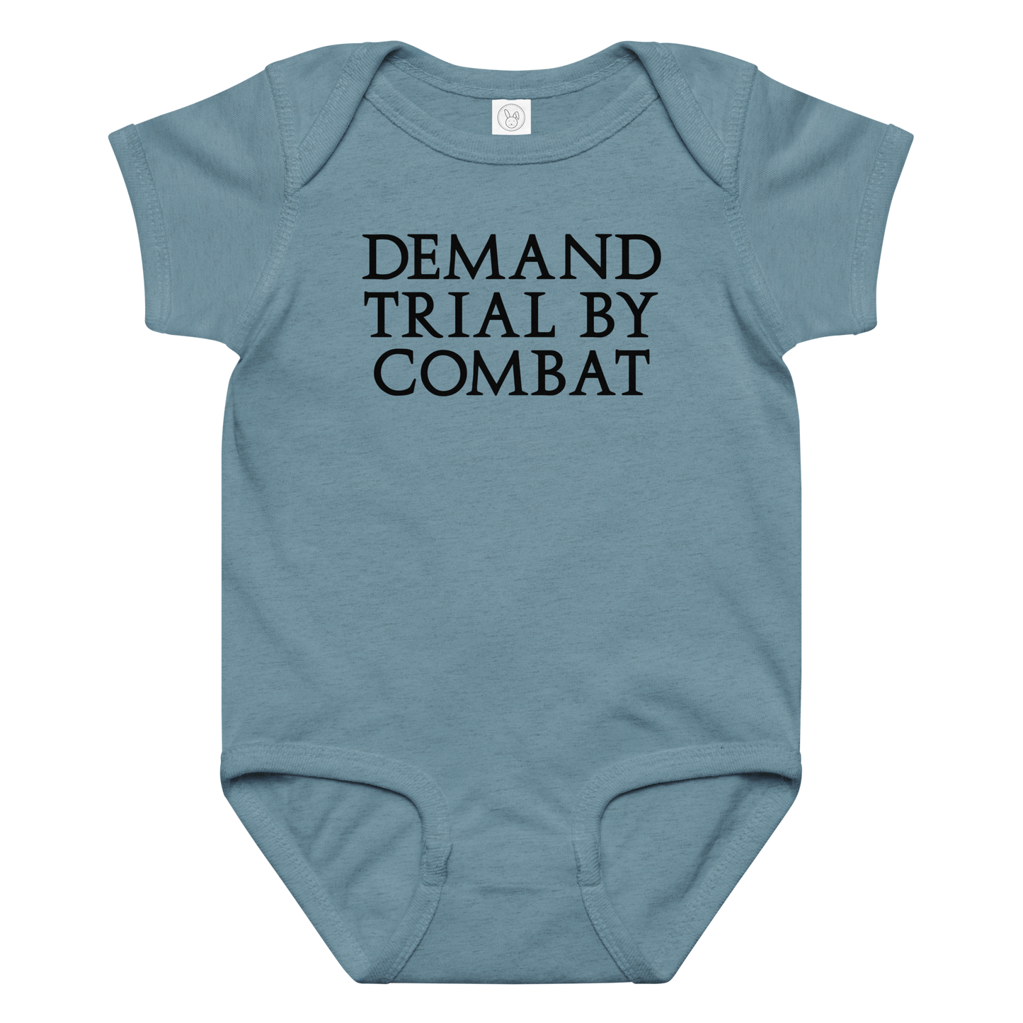 "Demand trial by combat" printed on a vintage indigo baby jersey bodysuit laying on a flat surface amongst other clothes