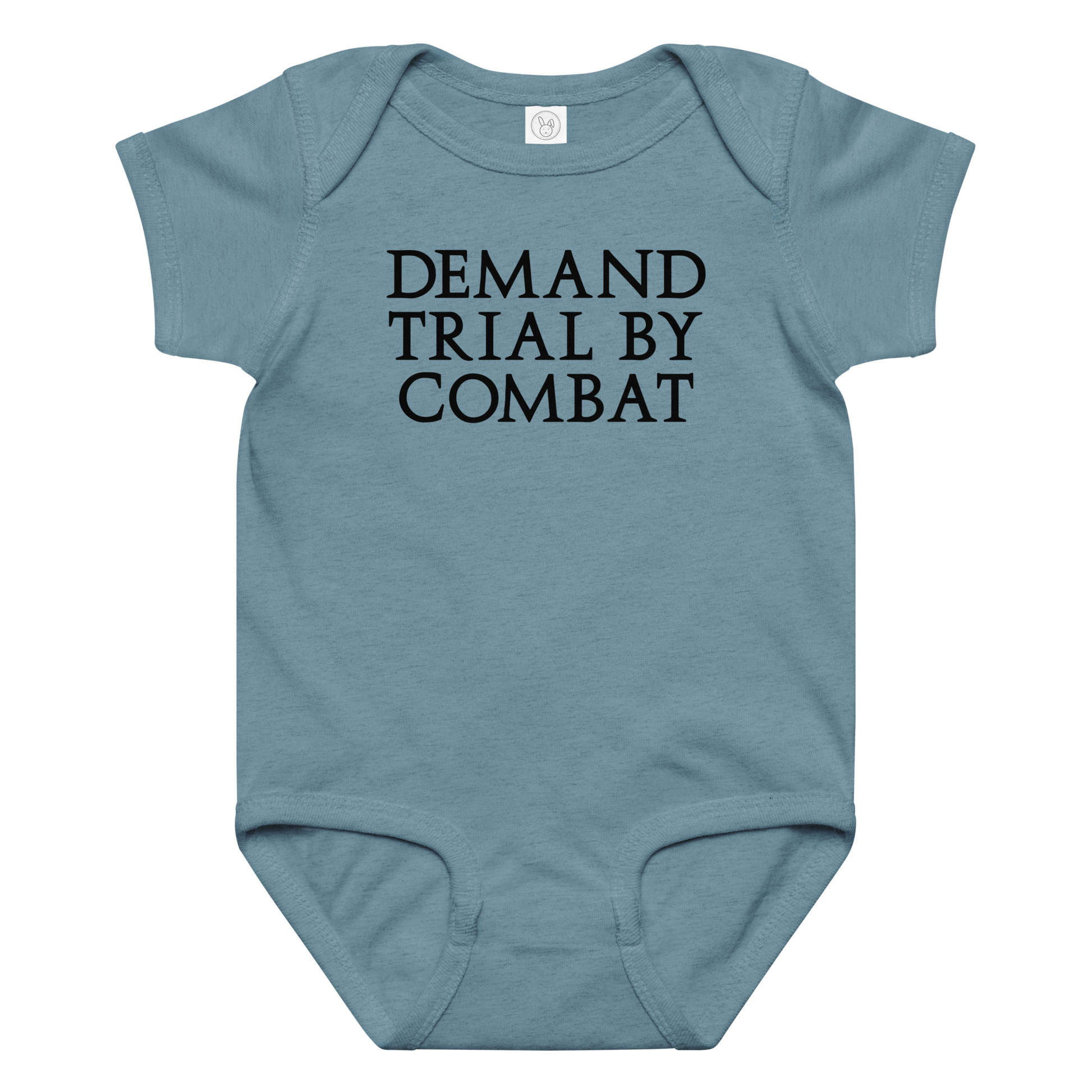 "Demand trial by combat" printed on a vintage indigo baby jersey bodysuit laying on a flat surface amongst other clothes