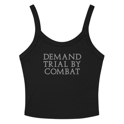 "Demand trial by combat" printed on a solid black blend women's micro-rib tanktop laying on a flat surface amongst sunglasses and shorts