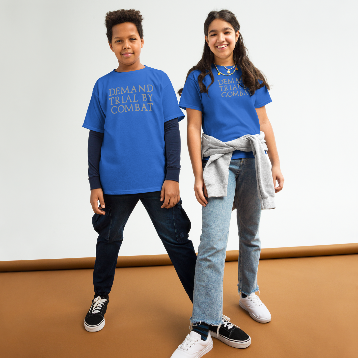 "Demand trial by combat" printed on a royal youth classic tee worn by a female and male