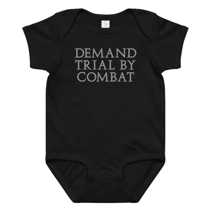 "Demand trial by combat" printed on a black baby jersey bodysuit laying on a flat surface amongst other clothes