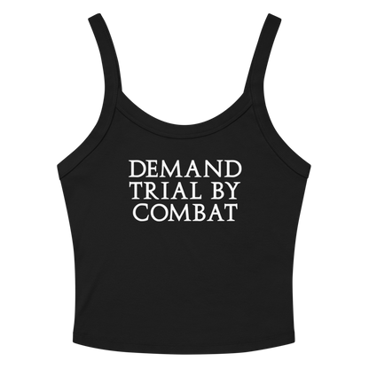 "Demand trial by combat" printed on a solid black blend women's micro-rib tanktop laying on a flat surface amongst sunglasses and shorts