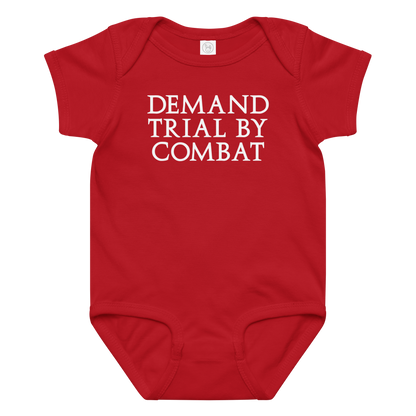 "Demand trial by combat" printed on a red baby jersey bodysuit laying on a flat surface amongst other clothes