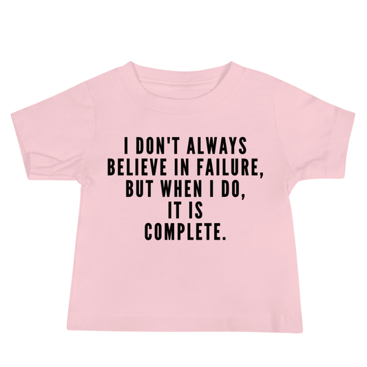 "I don't always believe in failure, but when I do, it is complete." printed on a pink baby jersey short sleeve tee laying on a flat surface